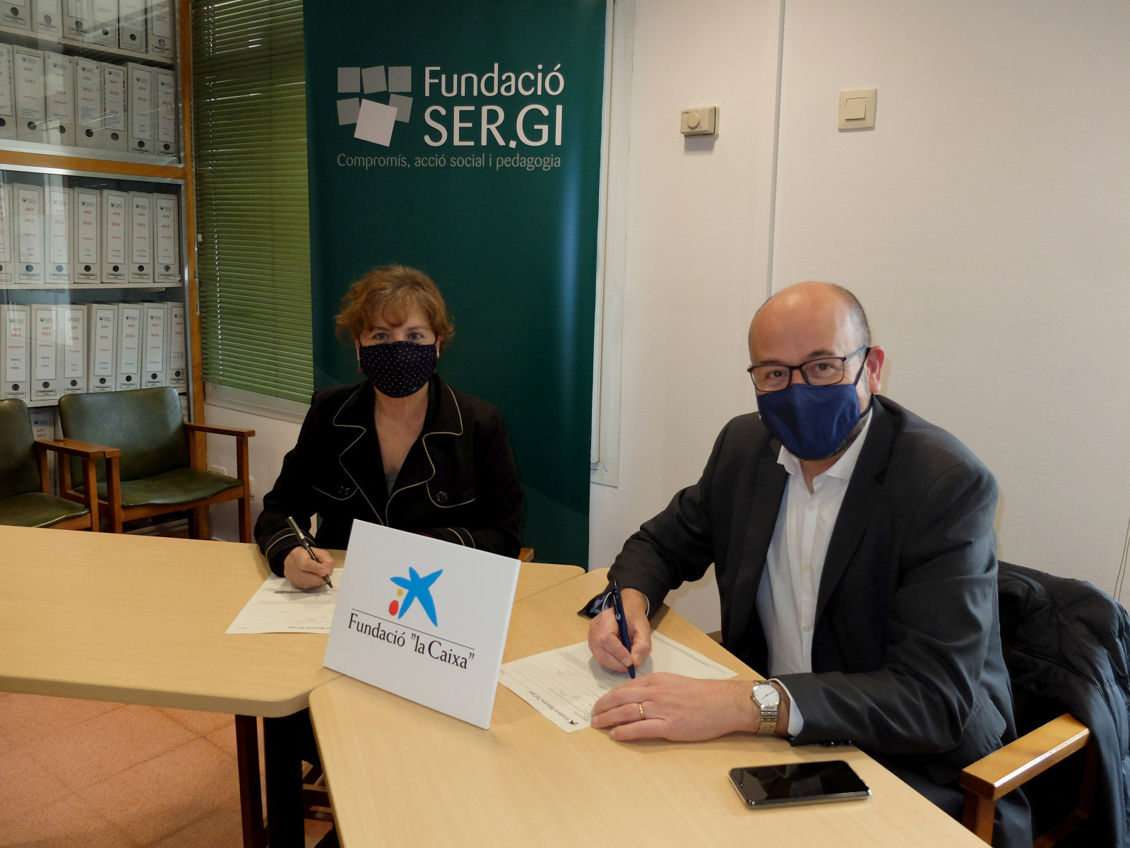 Montse Pasquina, patrona de Fundació SER.GI i Ferran Llach, director Banca institucions CaixaBank, en el moment de la signatura de la col·laboració.